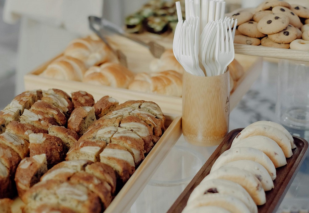 Wooden plates with disposable forks and straws.