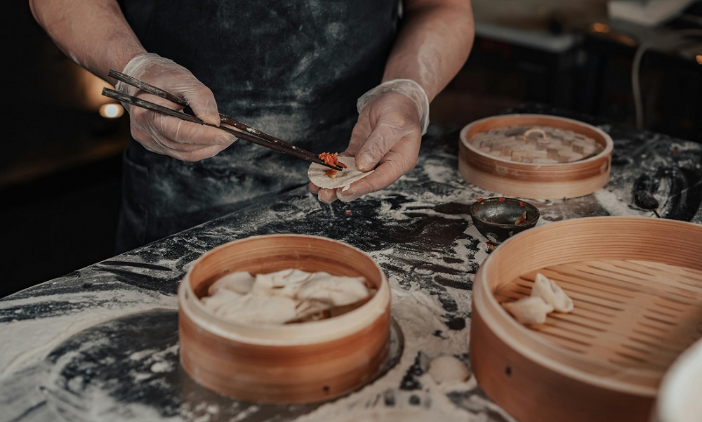 Restaurant chefs are placing wrapped dumplings on sustainable bamboo steamers.