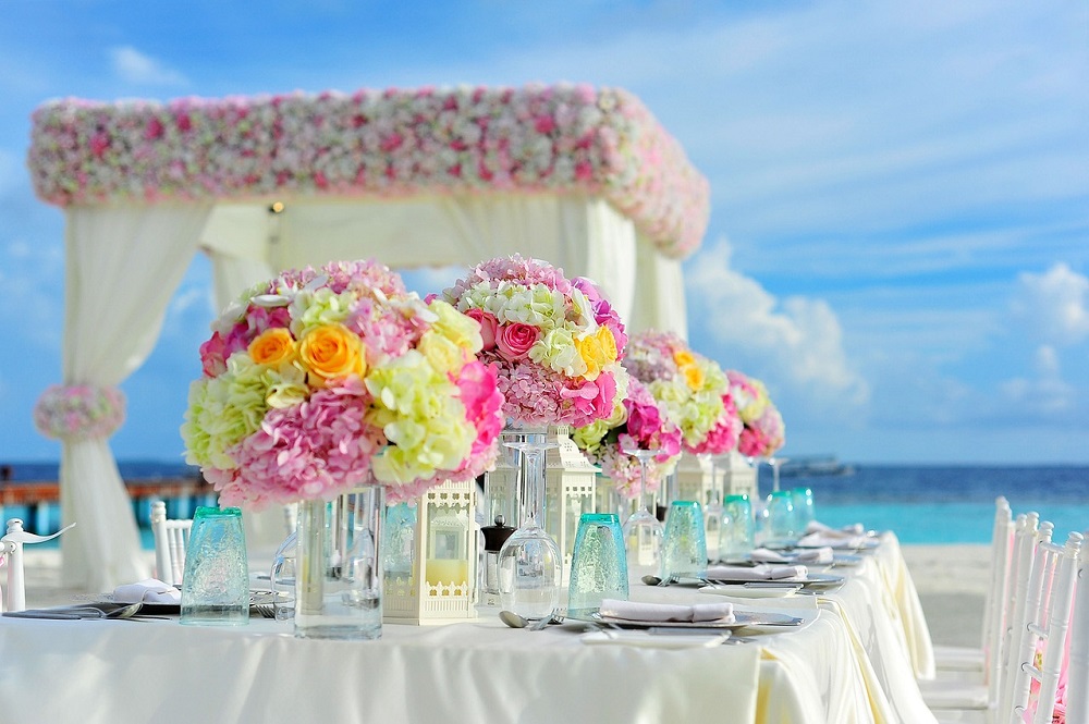 Plate and cutlery sets prepared for a seaside wedding.