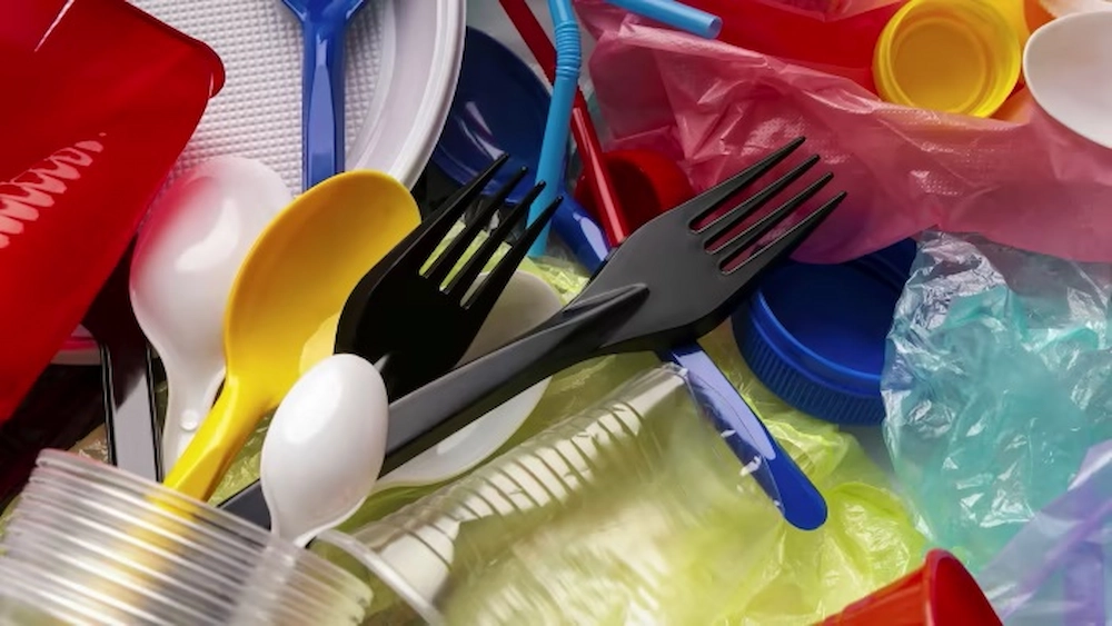 Discarded disposable tableware, including disposable forks, disposable spoons and cups.