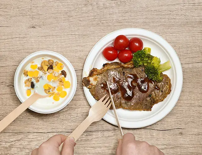 Wooden cutlery, sugarcane-based steak plates, and yogurt bowls