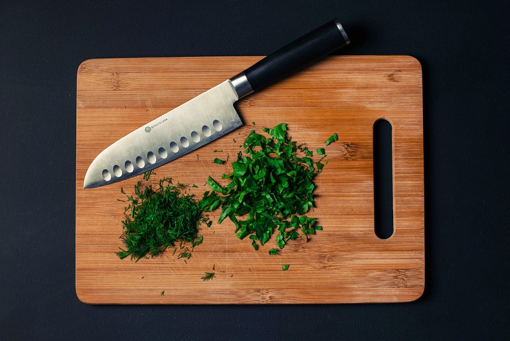 Bamboo cutting boards are being used as kitchen utensils for chopping vegetables.