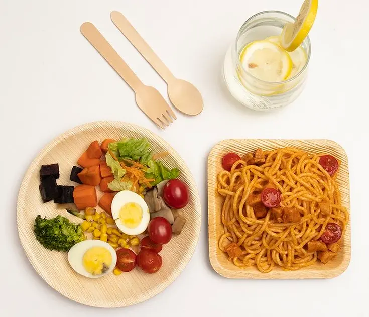 Disposable wooden spoons and forks, along with food plates.
