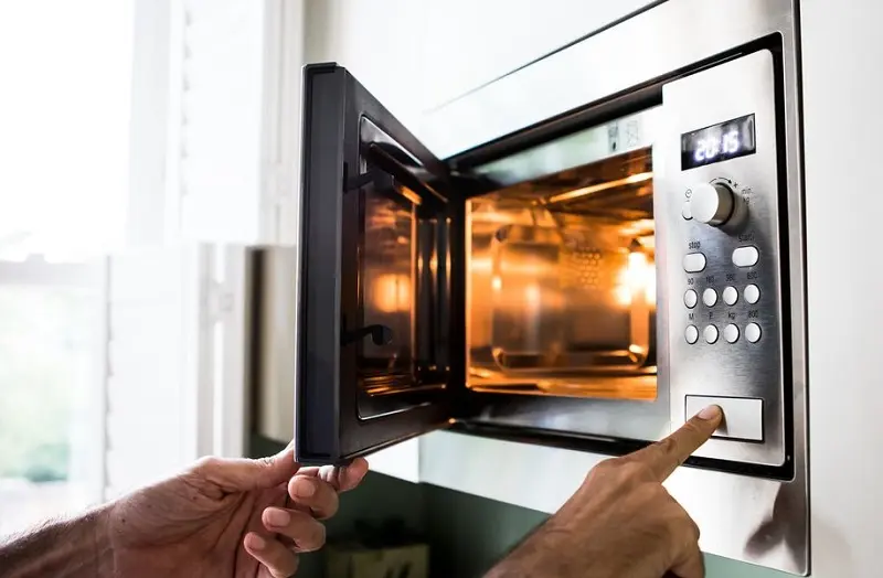 A person opened the microwave to heat something up.