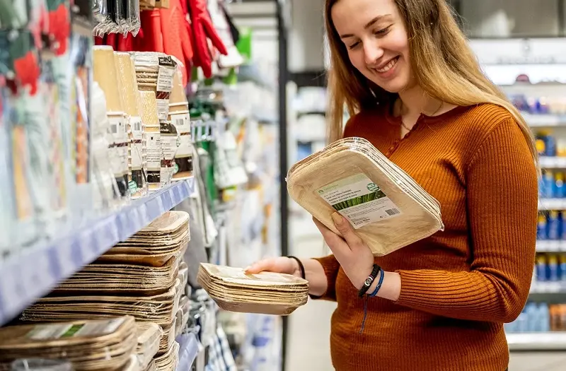 Consumers are selecting picnic tableware at the supermarket.